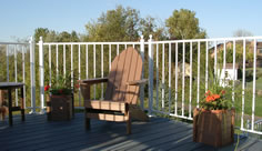 Residential colonial picket aluminum railing photo with composite chairs and planters by Versadeck Decking